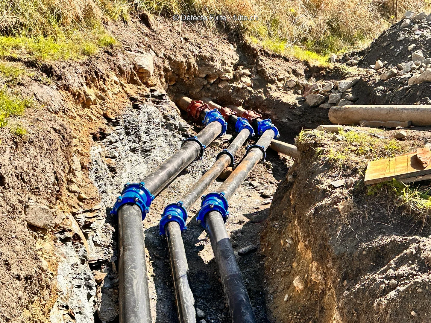 Des conduites et leurs raccordements dans une fouille.